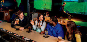 Group of friends enjoying the indoor golf driving range.
